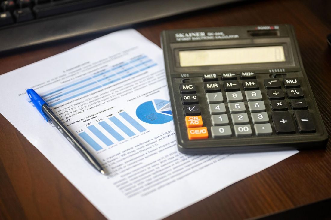 Calculadora e relatório com gráficos sobre a mesa
